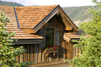 Modelo de fachada beige de estilo de casa de campo de tres plantas con revestimiento de madera