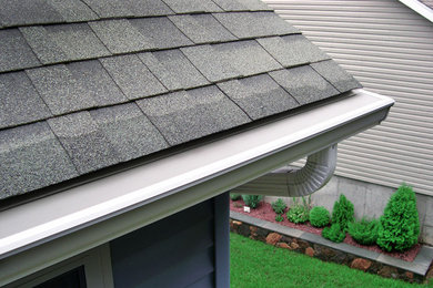 Example of a mid-sized classic white two-story vinyl gable roof design in Cleveland