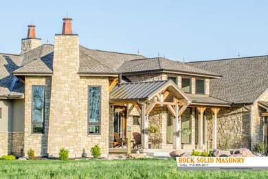 Inspiration for a rustic beige stone house exterior remodel in Kansas City