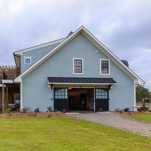 Example of a large farmhouse green two-story stucco gable roof design in Raleigh