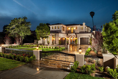 Example of a tuscan beige two-story stucco exterior home design in Los Angeles