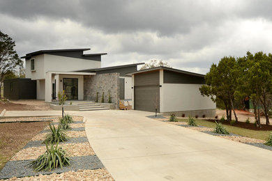 Example of a trendy white two-story exterior home design in Austin