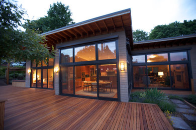 На фото: большой, одноэтажный, деревянный, серый дом в современном стиле с плоской крышей с