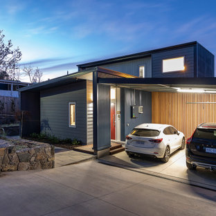 Modern inredning av ett litet grått hus, med två våningar, platt tak och tak i metall