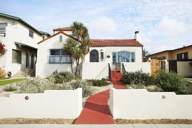 Inspiration for a mid-sized mediterranean white two-story exterior home remodel in San Diego with a tile roof