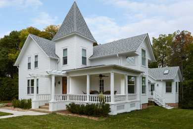 Example of an ornate white two-story clapboard exterior home design in Chicago with a shingle roof and a gray roof
