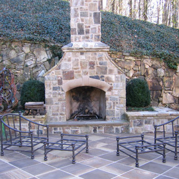 Grand Fieldstone fireplace, raised fieldstone planting beds and metalartwork