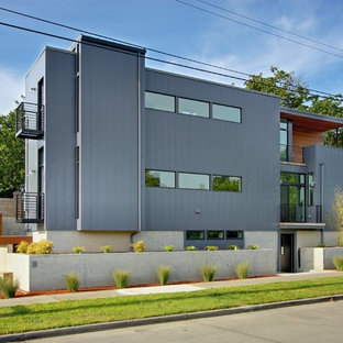 Imagen de fachada gris, contemporánea, pequeña, de tres plantas, con revestimiento de metal y tejado plano