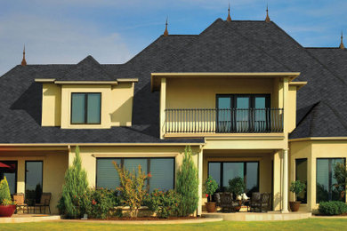 Foto de fachada de casa grande de dos plantas con tejado a cuatro aguas y tejado de teja de madera