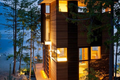 Large contemporary brown two-story wood house exterior idea in Vancouver with a shed roof and a metal roof