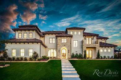 Large mediterranean white two-story stucco house exterior idea in Dallas with a tile roof