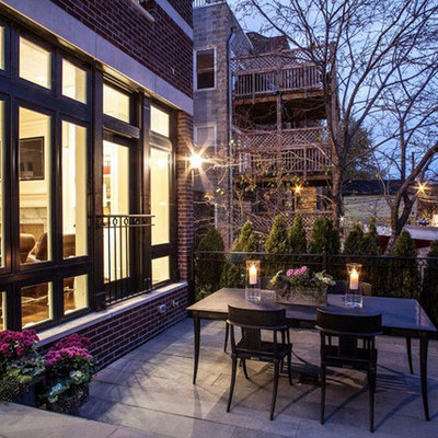 Large traditional brown three-story brick exterior home idea in Chicago