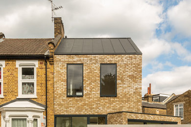 Inspiration for a brown contemporary two floor brick detached house in Vancouver with a pitched roof and a metal roof.