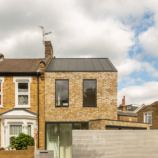 Inspiration for a brown contemporary two floor brick detached house in Vancouver with a pitched roof and a metal roof.