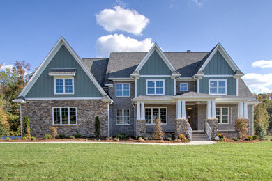 Inspiration for a large transitional gray two-story stone exterior home remodel in Other with a shingle roof
