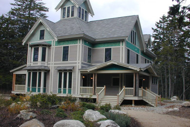 Imagen de fachada gris tradicional de tamaño medio de dos plantas con revestimiento de madera y tejado a cuatro aguas