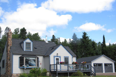 Imagen de fachada blanca tradicional de tamaño medio de una planta con revestimiento de madera y tejado a dos aguas