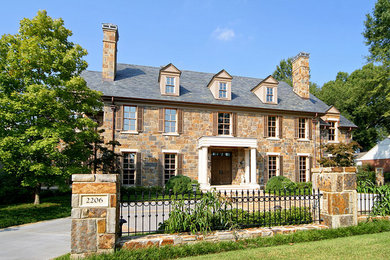 Ejemplo de fachada beige tradicional de tamaño medio de tres plantas con revestimiento de piedra y tejado a dos aguas
