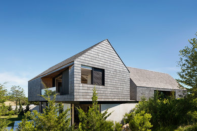 Foto de fachada de casa moderna de dos plantas con revestimiento de madera, tejado a dos aguas y tejado de teja de madera