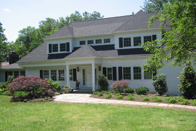 Example of a classic white two-story wood gable roof design in New York