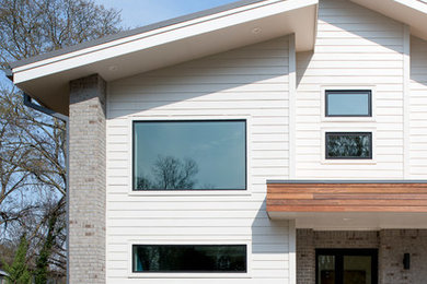 Imagen de fachada de casa minimalista de tamaño medio de dos plantas con tejado de un solo tendido y tejado de metal
