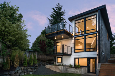 Cette photo montre une façade de maison grise moderne en panneau de béton fibré de taille moyenne et à deux étages et plus.