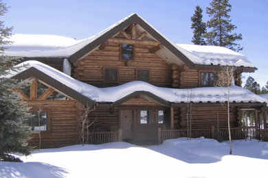 This is an example of a large and brown rustic two floor house exterior in Denver with wood cladding and a pitched roof.