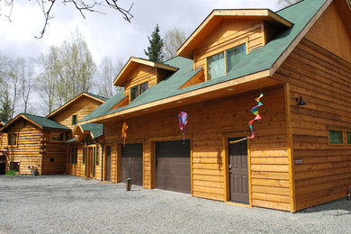 Ejemplo de fachada de casa rústica de dos plantas con revestimiento de madera, tejado a dos aguas y tejado de teja de madera