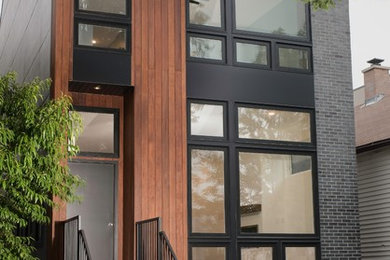 Example of a mid-sized trendy gray two-story brick house exterior design in Chicago