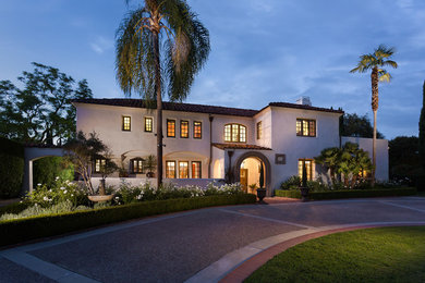 Example of a tuscan white two-story stucco house exterior design in Los Angeles with a tile roof