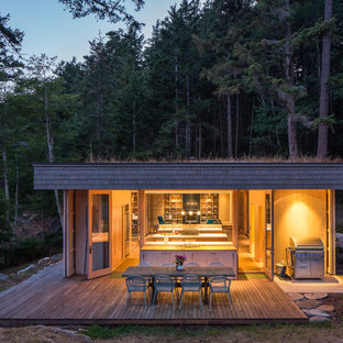 Foto della facciata di una casa rustica a un piano con rivestimento in legno e tetto piano