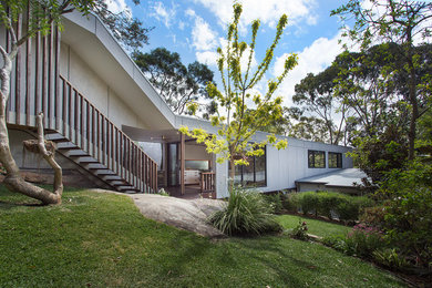 На фото: двухэтажный, серый дом среднего размера в стиле модернизм с облицовкой из ЦСП и плоской крышей