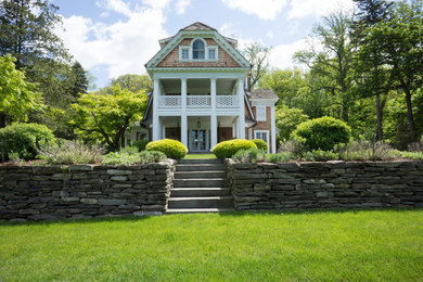 Example of a large classic three-story wood exterior home design in New York with a gambrel roof