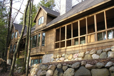 Aménagement d'une grande façade de maison marron craftsman en bois à un étage avec un toit à deux pans et un toit en shingle.