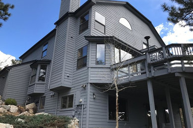 Imagen de fachada de casa gris grande de tres plantas con revestimiento de madera