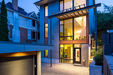 Inspiration pour une grande façade de maison grise design en adobe à deux étages et plus avec un toit plat.