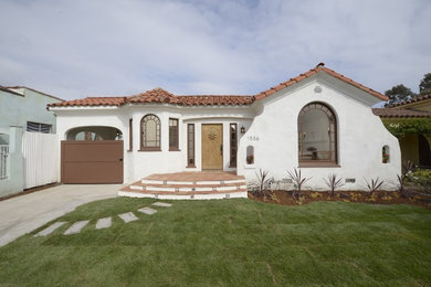 Photo of a white and medium sized mediterranean bungalow render house exterior in Los Angeles.