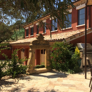 Photo of a large two-storey beige house exterior in San Francisco with stone veneer, a gable roof and a tile roof.
