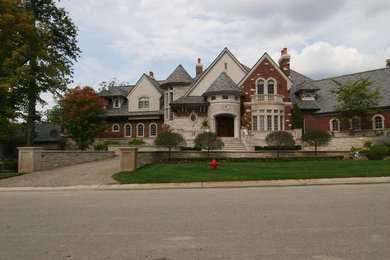 Large victorian brown three-story brick exterior home idea in Detroit