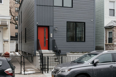 Inspiration pour une petite façade de maison grise minimaliste à un étage avec un toit plat.