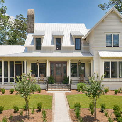 Example of a mid-sized country white two-story wood exterior home design in Other with a metal roof