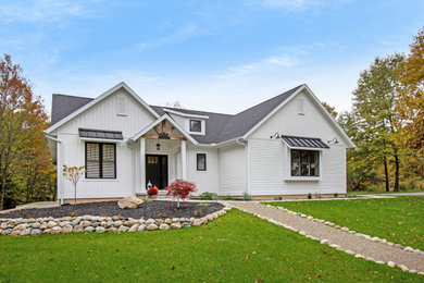 Cette photo montre une façade de maison blanche nature de taille moyenne et à un étage avec un toit à deux pans et un toit en shingle.