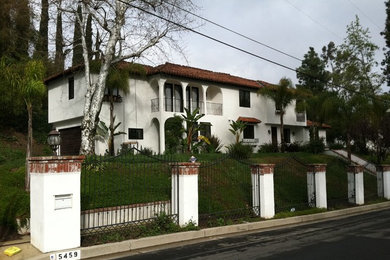Diseño de fachada de casa blanca mediterránea grande de dos plantas con revestimiento de piedra y tejado plano