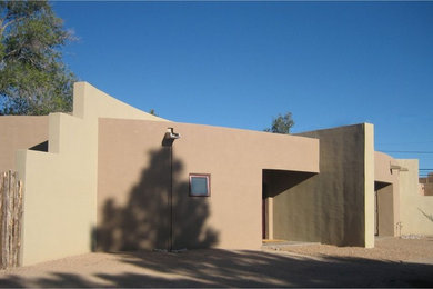 Diseño de fachada beige contemporánea de tamaño medio de una planta con revestimiento de estuco y tejado plano
