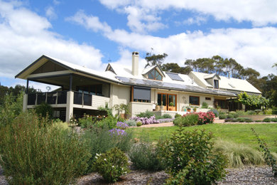 Foto de fachada de casa beige actual extra grande a niveles con revestimiento de hormigón, tejado a dos aguas y tejado de metal