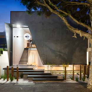 Photo of a large contemporary two-storey concrete grey house exterior in Melbourne with a flat roof and a metal roof.