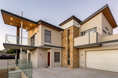Example of a large trendy beige two-story exterior home design in Perth with a metal roof