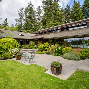 Photo of an expansive asian one-storey brown house exterior in Seattle with wood siding, a gable roof and a shingle roof.