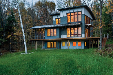 Bild på ett stort funkis grönt hus, med tre eller fler plan, blandad fasad och pulpettak