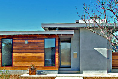 Ejemplo de fachada gris contemporánea de tamaño medio con revestimiento de madera
